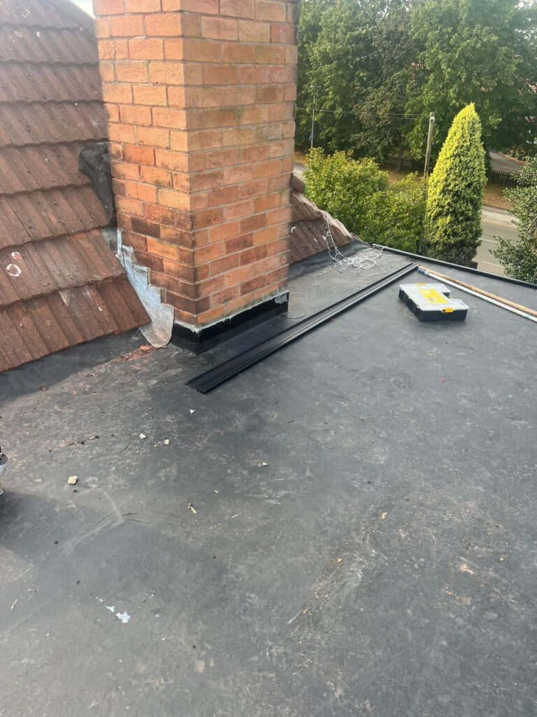 This is a photo of a flat roof which has just been repaired, there is also a chimney stack and some leadwork has also been dressed. Works carried out by Whetstone Roofing Repairs